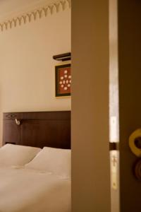 1 dormitorio con 1 cama y reloj en la pared en Grand Hotel Bellevue London en Londres