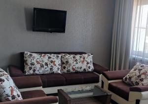 a living room with a couch and a flat screen tv at Hotel LUX in Tbilisi City