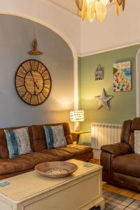 sala de estar con sofá y reloj en la pared en Beach House, en Lytham St Annes