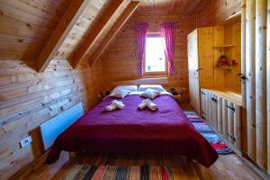 a bedroom with a bed in a wooden cabin at Riverside Apartments in Otočac