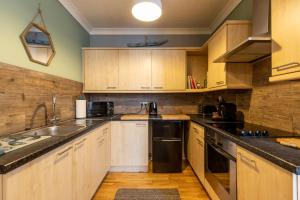 cocina con armarios de madera y nevera negra en Beach House, en Lytham St Annes