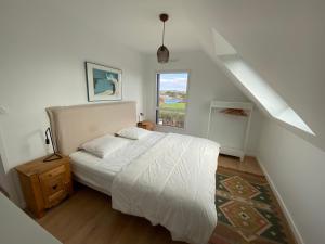 - une chambre avec un lit blanc et une fenêtre dans l'établissement Maison neuve, chaleureuse, vue sur L'Aber Benoït, à Saint-Pabu