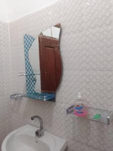 ein Bad mit einem Waschbecken und einem Spiegel in der Unterkunft Les Signares in Sor