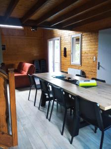 a dining room with a table and chairs and a couch at Chalet idéal 4-8 pers avec garage 20 mn Gérardmer in Vienville