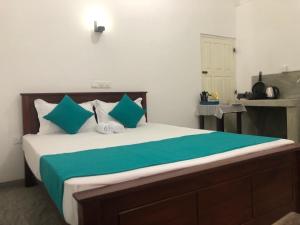 una camera da letto con un letto grande con cuscini verdi e bianchi di Waves a Hikkaduwa Altre 37 foto