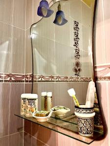 a shelf in a bathroom with a mirror and tooth brushes at Belle villa privé in Ounara