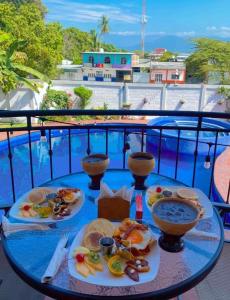 a table with two plates of food on a balcony at HOTEL MILIN in Villa Comaltitlán