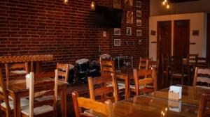 a dining room with tables and chairs and a brick wall at HOTEL MILIN in Villa Comaltitlán