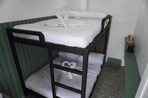 łóżko piętrowe z białą pościelą i ręcznikami w obiekcie Cebu Backpackers Hostel w Cebu