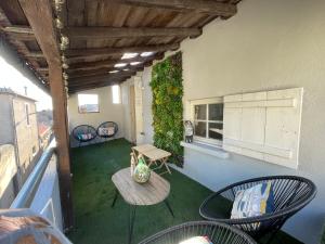 ein Balkon mit Tisch und Stühlen auf einem Gebäude in der Unterkunft Maison Petit Arago avec roof terrace et parking privé in Carcassonne