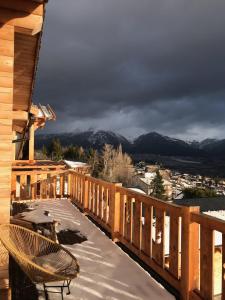 a wooden deck with a bench and mountains in the background at Chalet Cervus in Font-Romeu-Odeillo-Via