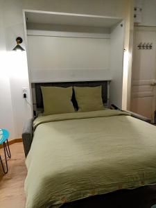- une chambre avec un grand lit et une grande tête de lit dans l'établissement Studio La Cabine, à Mers-les-Bains