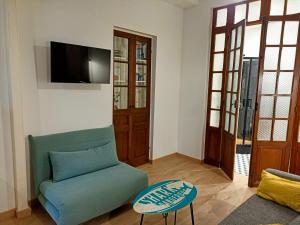 a living room with a green couch and a tv at Studio La Cabine in Mers-les-Bains