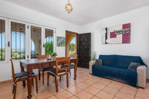 een woonkamer met een tafel en een blauwe bank bij Villa Rodrigo - PlusHolidays in Benissa