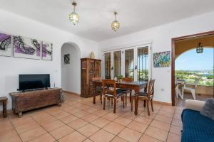 een woonkamer met een tafel en een televisie bij Villa Rodrigo - PlusHolidays in Benissa