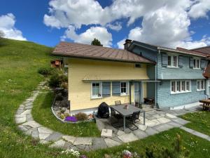 ein Haus mit einem Tisch davor in der Unterkunft Undereggli in Nesslau