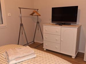 Bienvenue chez toi - TV, WiFi في Castanet-Tolosan: غرفة نوم مع تلفزيون فوق خزانة