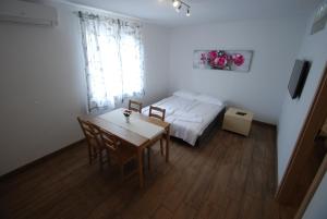 een slaapkamer met een bed en een tafel en stoelen bij Apartments Maraž in Portorož