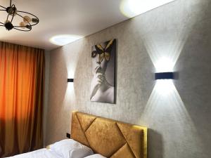 1 dormitorio con 1 cama con 2 luces en la pared en Апартаменти Еліт, Центр, ЖК Яровиця en Luts'k