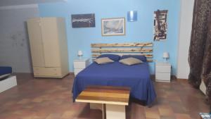 1 dormitorio con cama y pared azul en B&B Stars and Stripes en Monopoli