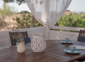 una mesa de madera con dos platos y un jarrón en ella en Molino Sa Miranda - Formentera Break, en Sant Francesc Xavier
