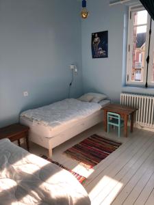 een slaapkamer met een bed, een tafel en een raam bij Villa Centre ville et plage Le Mascaret in Villers-sur-Mer