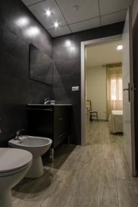 bagno con lavandino, servizi igienici e specchio di CASA CON PATIO a Pozoblanco