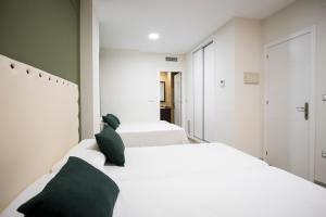 2 letti bianchi in una stanza con pareti verdi di CASA CON PATIO a Pozoblanco