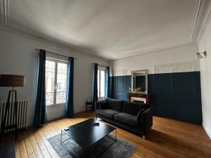 a living room with a couch and a table at Appartements Plantagenet - Le 33 in Le Mans