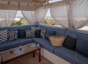 Sofá azul en una habitación con mesa en Molino Sa Miranda - Formentera Break, en Sant Francesc Xavier