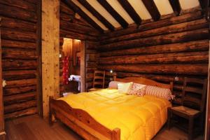 ein Schlafzimmer mit einem Bett in einer Blockhütte in der Unterkunft Stadel Soussun in Champoluc + 69 Fotos
