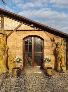ein Gebäude mit einer Tür und zwei Pflanzen in Fässern in der Unterkunft AGRODEO Gospodarstwo Agroturystyczne in Gąsawa