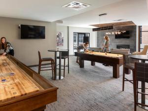 a group of people playing a game of billiard in a room at Larimer Square, Parking included, at The Windsor in Denver