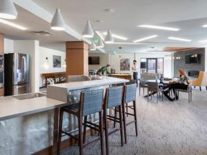 a kitchen and living room with a counter and chairs at Larimer Square, Parking included, at The Windsor in Denver