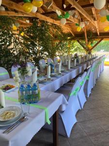 een lange tafel met witte stoelen en flessen water bij AGRODEO Gospodarstwo Agroturystyczne in Gąsawa