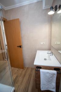 ein Badezimmer mit einem weißen Waschbecken und einer Dusche in der Unterkunft Apartamentos 7 puentes sierra Cazorla Casa Acebo in Burunchel + 56 Fotos