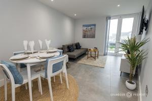 a living room with a white table and chairs at Newly Built 2br Apartment near Sandy Beaches and Tuckton Village - Meraki Vista in Bournemouth