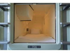 東京にあるMale Only Capsule Inn Hamamatsucho - Vacation STAY 68799vの小さなお部屋で、時計の内側にベッドが備わります。