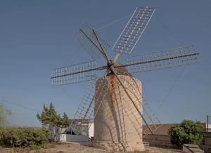 a stone windmill with a blue sky in the background at Molino Sa Miranda - Formentera Break in Sant Francesc Xavier