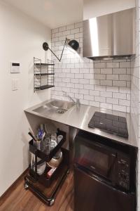 a kitchen with a sink and a stove at Style Wood Nishi-Shinjuku 2nd floor 3rd floor - Vacation STAY 68984v in Tokyo