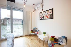 salon z kanapą, krzesłami i oknem w obiekcie The Boutique Apartment w Belgradzie
