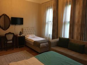 Habitación de hotel con cama, sofá y espejo en Amida House, en Estambul