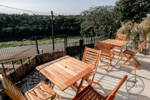 un tavolo e sedie in legno su una terrazza con tavolo e sedie. di ISONDU Suites & Breakfast a Puerto Iguazú