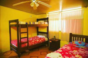 a bedroom with two bunk beds and a ceiling fan at Hostal Henrry's in Mindo