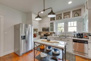a kitchen with a stainless steel refrigerator and wooden floors at Canton Home with Porch Less Than 1 Mile to First Monday! in Canton