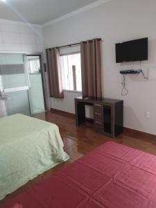 a bedroom with a bed and a flat screen tv at Bom Jardim in Piauí