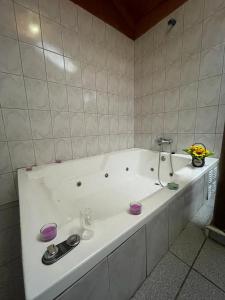 uma grande banheira branca na casa de banho em Restaurant y Hostería El Tucán em San José de Maipo