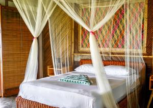 a bedroom with a bed with a canopy at Eco Sanctuaries Nature Lodge Nacpan Beach, El Nido in El Nido