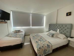 Habitación de hotel con 2 camas y TV en Hermoso edificio de frente al mar, en Cartagena de Indias