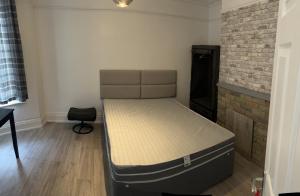 uma cama num quarto com uma parede de tijolos em Excellent 3bed flat em Kent